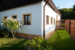 una casa blanca con una valla y un patio en Chalupa Barborka en Mezimesti