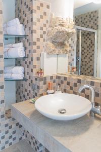 ein Badezimmer mit einem Waschbecken und Handtüchern auf der Theke in der Unterkunft Il Giardino sul Tetto B&B in Guarene