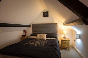 ein Schlafzimmer mit einem großen Bett im Dachgeschoss in der Unterkunft Pikes Barn in Taunton