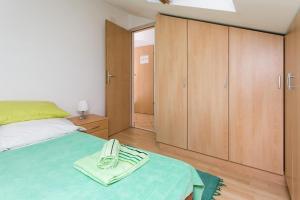 a bedroom with a bed and wooden cabinets at Apartment Lala in Dubrovnik