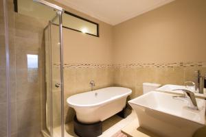 a bathroom with a sink and a shower and a toilet at Zimbali Holiday Home - 3 Baluwatu in Durban +19 photos