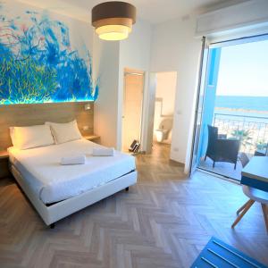 - une chambre avec un lit et une peinture murale dans l'établissement Hotel La Perla, à Bellaria-Igea Marina