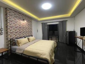 ein Schlafzimmer mit einem großen Bett mit einer Wand in der Unterkunft Re-Live Resort in Ban Bang Phra