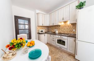 een keuken met witte kasten en een tafel met fruit erop bij Шикарная квартира на Оболони в ЖК Яскравый in Kiev