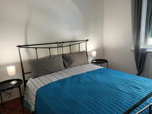 Schlafzimmer mit einem Bett mit blauer Decke in der Unterkunft Raffaello in Iesi