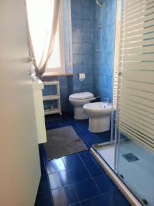 Baño azul con aseo y lavamanos en Raffaello, en Iesi