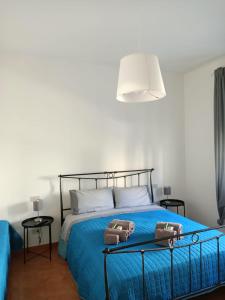 Un dormitorio con una cama azul con dos bolsas. en Raffaello, en Iesi