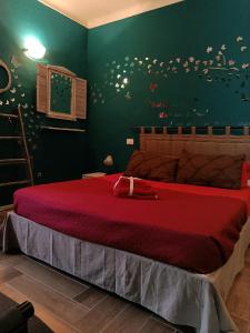 a bedroom with a bed with red sheets and butterflies on the wall at CA MATILDE in Ivrea