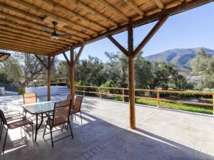 a patio with a table and chairs and a view at Cortijo villa maroma in Órgiva