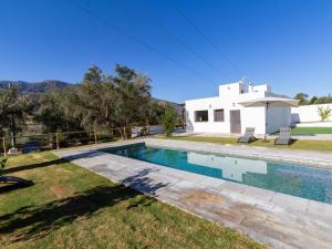 une villa avec une piscine en face d'une maison dans l'établissement Cortijo villa maroma, à Órgiva