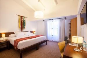 a hotel room with a bed and a desk and a window at Tierra Viva Cusco San Blas in Cusco