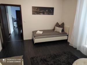 - un petit lit dans une chambre avec un miroir dans l'établissement Apartman MB, à Poprad