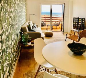 a living room with a couch and a table at Costa Caparica surf apartment in Costa da Caparica