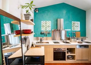 una cocina con paredes verdes y una cocina con fregadero en KēSa House, The Unlimited Collection managed by The Ascott Limited en Singapur