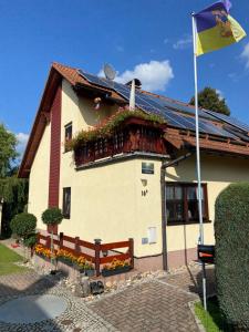 a house with a flag on the side of it at Ferienwohnung Heymann in Hörnitz