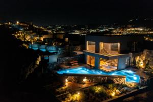 a house lit up at night with lights at Acro Suites - A Wellbeing Resort in Agia Pelagia