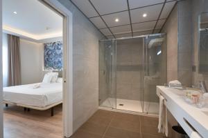 a bathroom with a shower, sink, and tub at Monte Triana in Seville