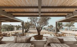 une terrasse avec des canapés, des tables et des chaises dans l'établissement Cove Paros, à Náoussa