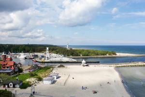 une plage avec un port de plaisance et des bateaux dans l'eau dans l'établissement Radość Natura Tour, à Ustka