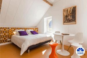 ein Schlafzimmer mit einem Bett und einem Tisch darin in der Unterkunft Villa Juno - Saint-Aubin-sur-Mer - Côte de nacre - Normandie - Plage débarquement in Saint-Aubin-sur-Mer