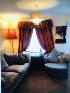 ein Wohnzimmer mit einem Sofa und einem Fenster in der Unterkunft Lazy Nest is a Lazy comfortable Nest to laze in Oakham