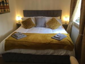 a bedroom with a bed with towels on it at Lazy Nest is a Lazy comfortable Nest to laze in Oakham