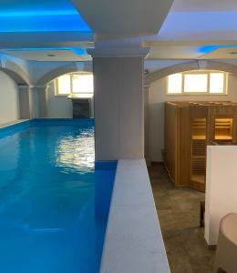 una piscina con agua azul en una habitación en Tysandros Hotel Apartments, en Giardini Naxos