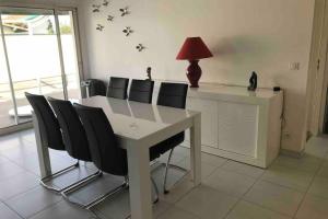 a dining room table with black chairs and a red lamp at Maison lumineuse 3 chambres bordeaux sud in Pont-de-la-Maye