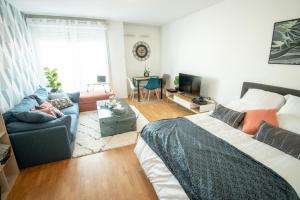 a living room with a bed and a couch at Appartement chic avec parking gratuit à Paris in Gentilly