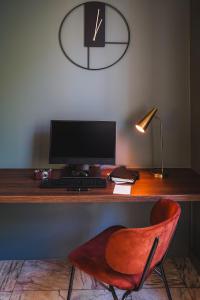 - un bureau avec un ordinateur et une chaise rouge dans l'établissement Timhotel Invalides Eiffel, à Paris