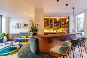 a bar in a living room with a couch and chairs at Timhotel Invalides Eiffel in Paris