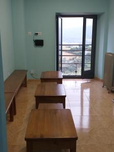 a room with two benches and a door with a balcony at Albergue La Plaza in Tineo