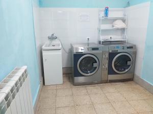 eine Waschküche mit zwei Waschmaschinen und einer Waschmaschine in der Unterkunft Albergue La Plaza in Tineo