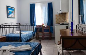 ein Schlafzimmer mit zwei Betten und eine Küche mit einem Tisch in der Unterkunft Vrahia Studios in Agiassos + 40 Fotos