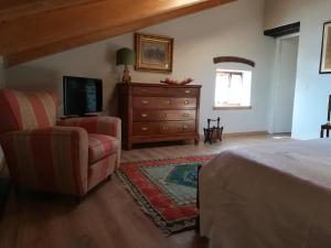 1 dormitorio con cama, silla y vestidor en Alloggio Alla Collina, en Arcugnano