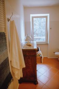 a bathroom with a sink and a towel on a counter at La Foresteria di Villa Piazzo in Pettinengo