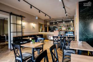 un ristorante con tavoli e sedie e un bar di Hotel POD RÓŻAMI a Jedlnia-Letnisko