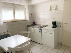 uma pequena cozinha branca com uma mesa e um balcão em FeWo25-Zimmer-am-Bodensee em Markdorf