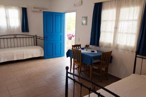 a dining room with a table and a blue door at Vrahia Studios in Agiassos
