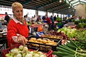 an older woman standing in a market with vegetables at Piso céntrico y tranquilo en Gernika in Guernica y Luno