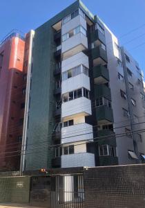 a tall apartment building with a fence in front of it at 2 min do mar Ponta Verde in Maceió