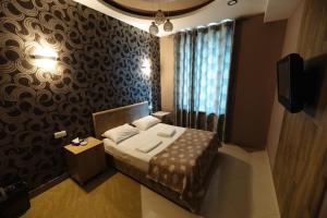 una piccola camera con letto e TV di GOLDEN SECONDS Hotel a Yerevan