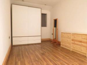 an empty room with a large white closet and wooden floors at Modern split level flat in Croydon (south) London in London