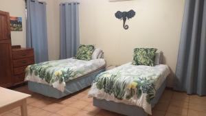 Un dormitorio con dos camas y una cómoda. en Hooked on 6 Fish Eagles, en St Lucia