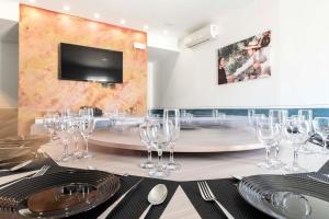 una mesa con copas de vino y una TV en la pared en Mini Hotel Wf2 Caltagirone en Caltagirone