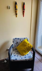a chair with a pillow and two masks on the wall at Sunny Parkside Apartment in Bar
