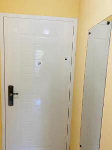 a bathroom with a white door and a mirror at Sunny Parkside Apartment in Bar +6 photos