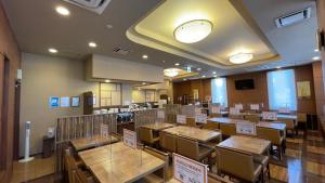 uma sala de jantar com mesas e cadeiras com placas em Hotel Route-Inn Iyo-Saijo em Saijo