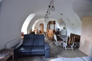 a living room with a blue couch and a table at The Wine Cellar in the Old Gemeinde House in Brauneberg