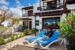 una villa con patio arredato con sedie e tavolo di Casa Del Mar a Playa Blanca